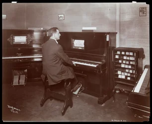 Ein Mann spielt ein Pianola in einem Klaviersalon in New York, 1907